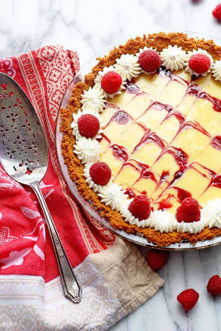 Best key lime pie in the form topped with raspberries and whipped cream.