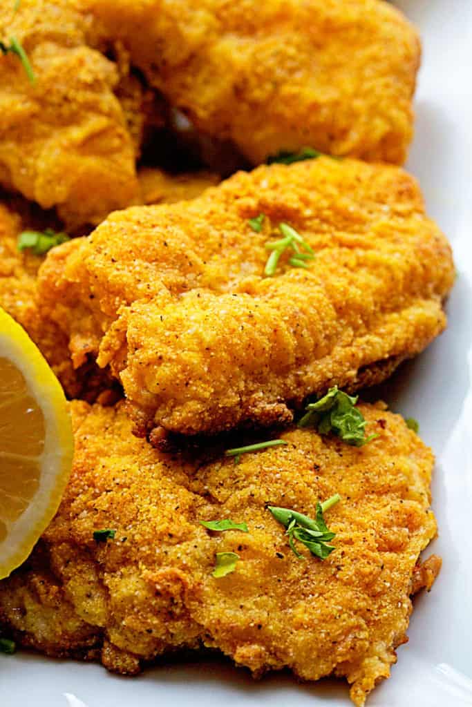 Close up of Golden crunchy oven fried catfish served on a white plate