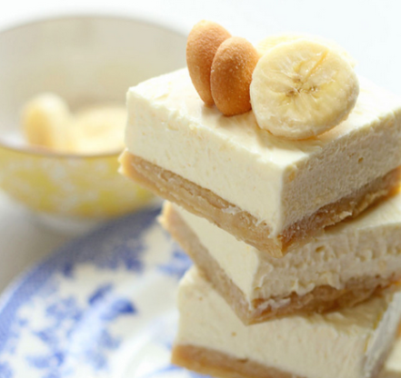 3 Banana Pudding Cheesecake Blondies stacked on top of each other sitting on a white and blue plate.