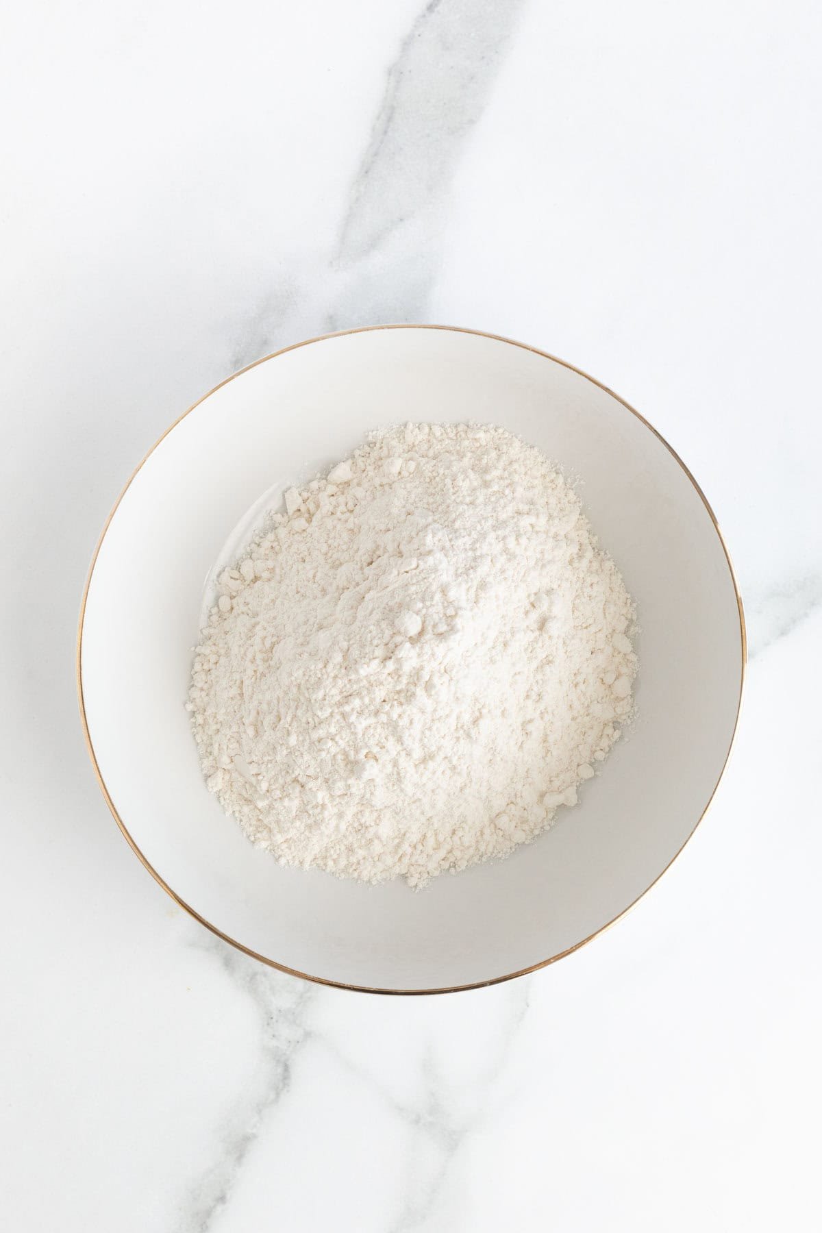 White bowl filled with all-purpose flour for dredging fish