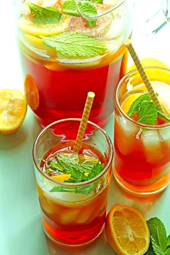 Pitcher of sweet tea with two glasses full of southern sweet tea and ice cubes.