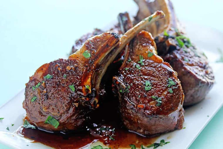 This Best Lamb Chops recipe flavored with balsamic vinegar and brown sugar resting on a white plate.