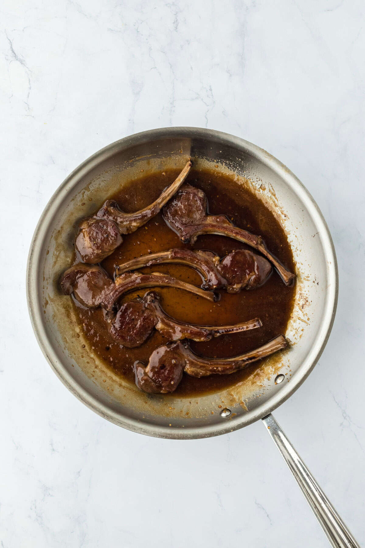 Chops basting in a sauce and cooking.