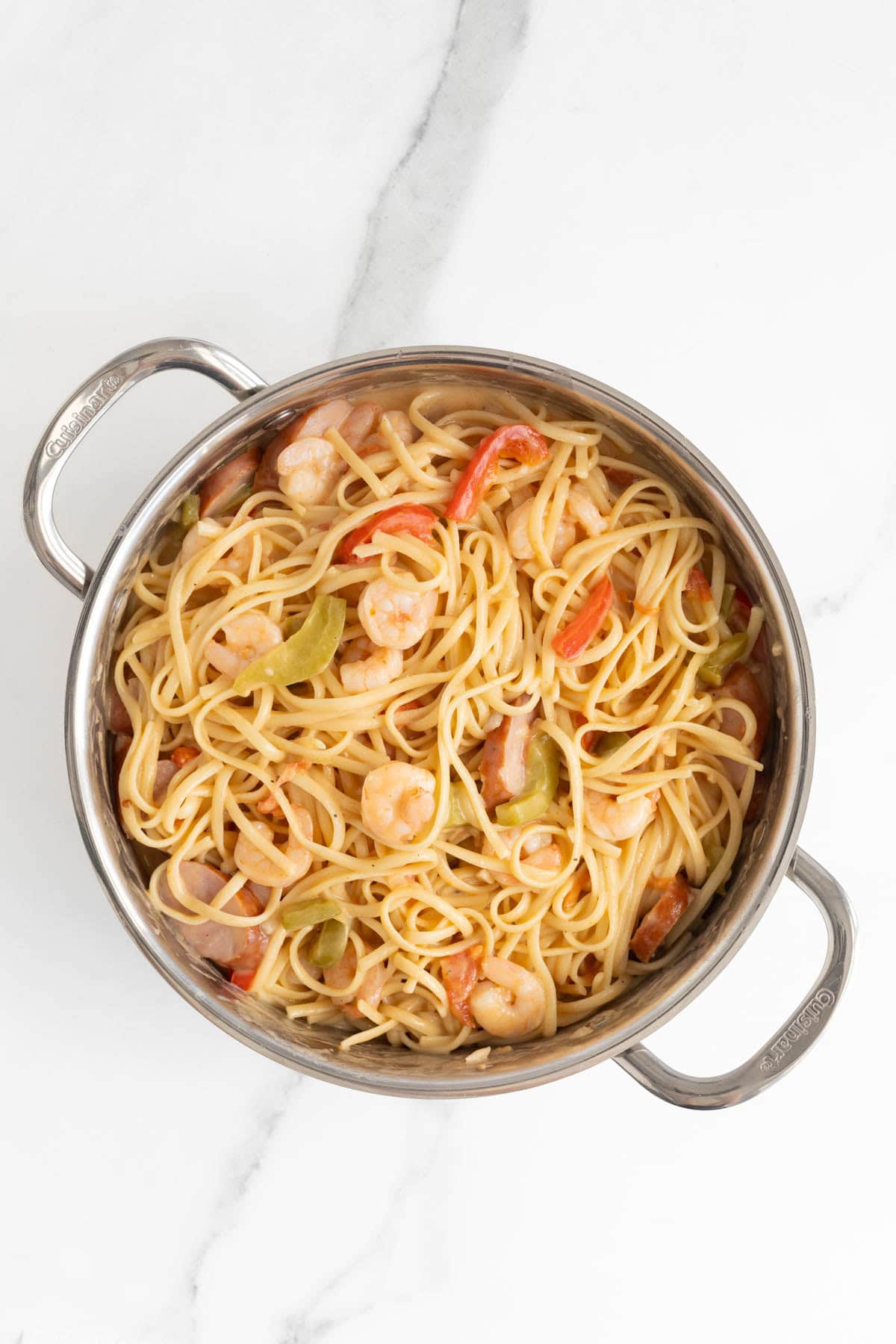 Fully mixed Cajun shrimp pasta with linguine in a stainless steel pot
