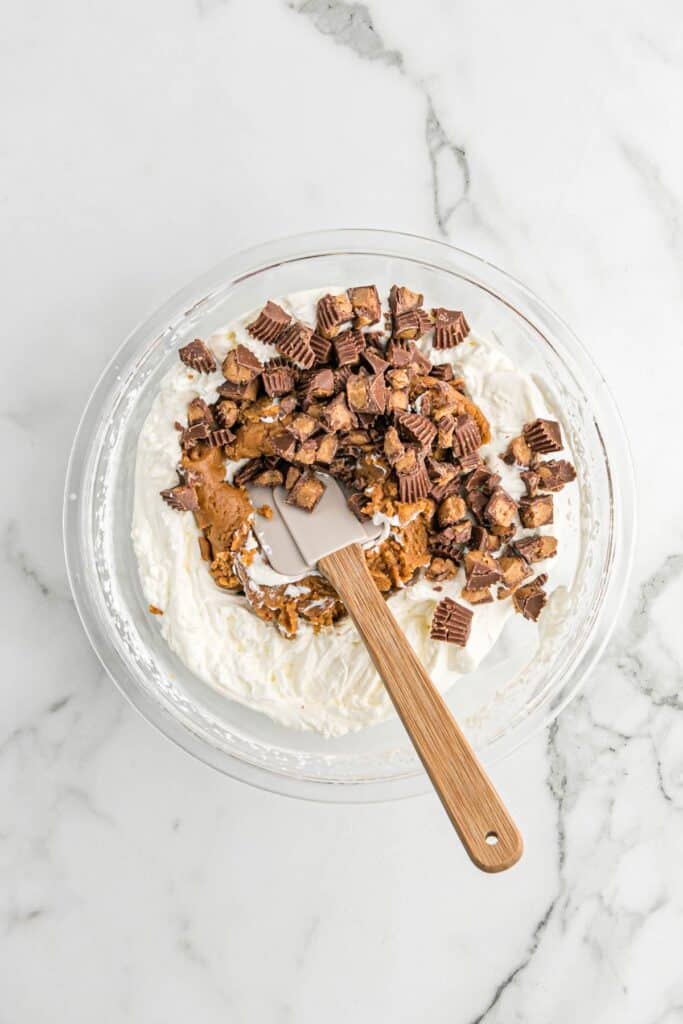 Mixing the two mixtures together with the peanut butter cup pieces.