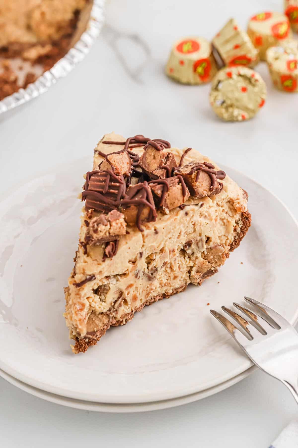 A slice of no bake peanut butter pie on a plate with a pie in the background.