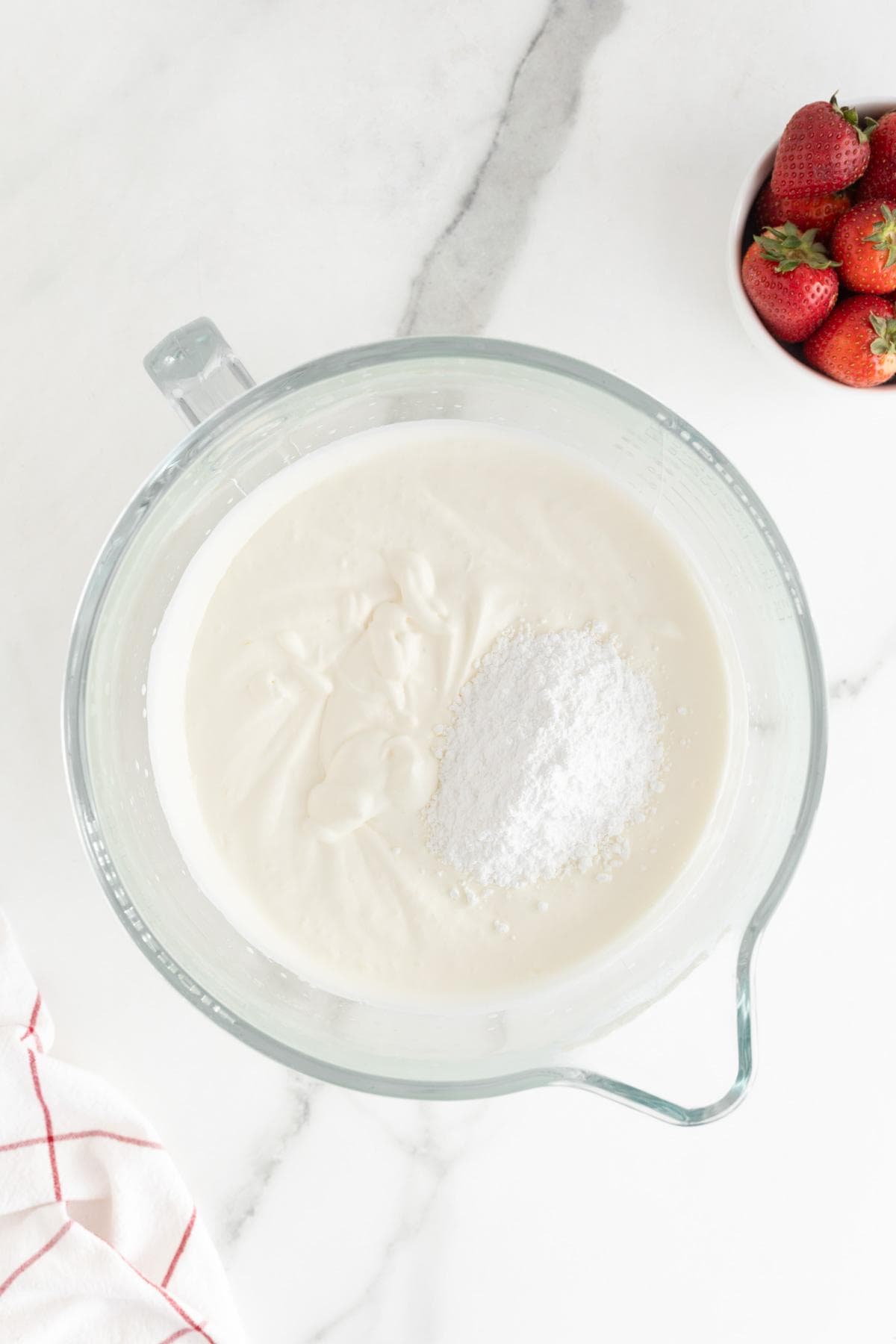 Whipped cream being prepared, with powdered sugar sprinkled on top