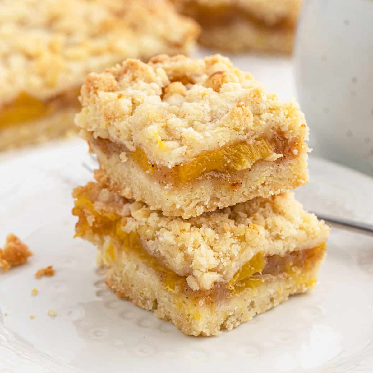 Peach Crumb Bars in a stack on a white plate