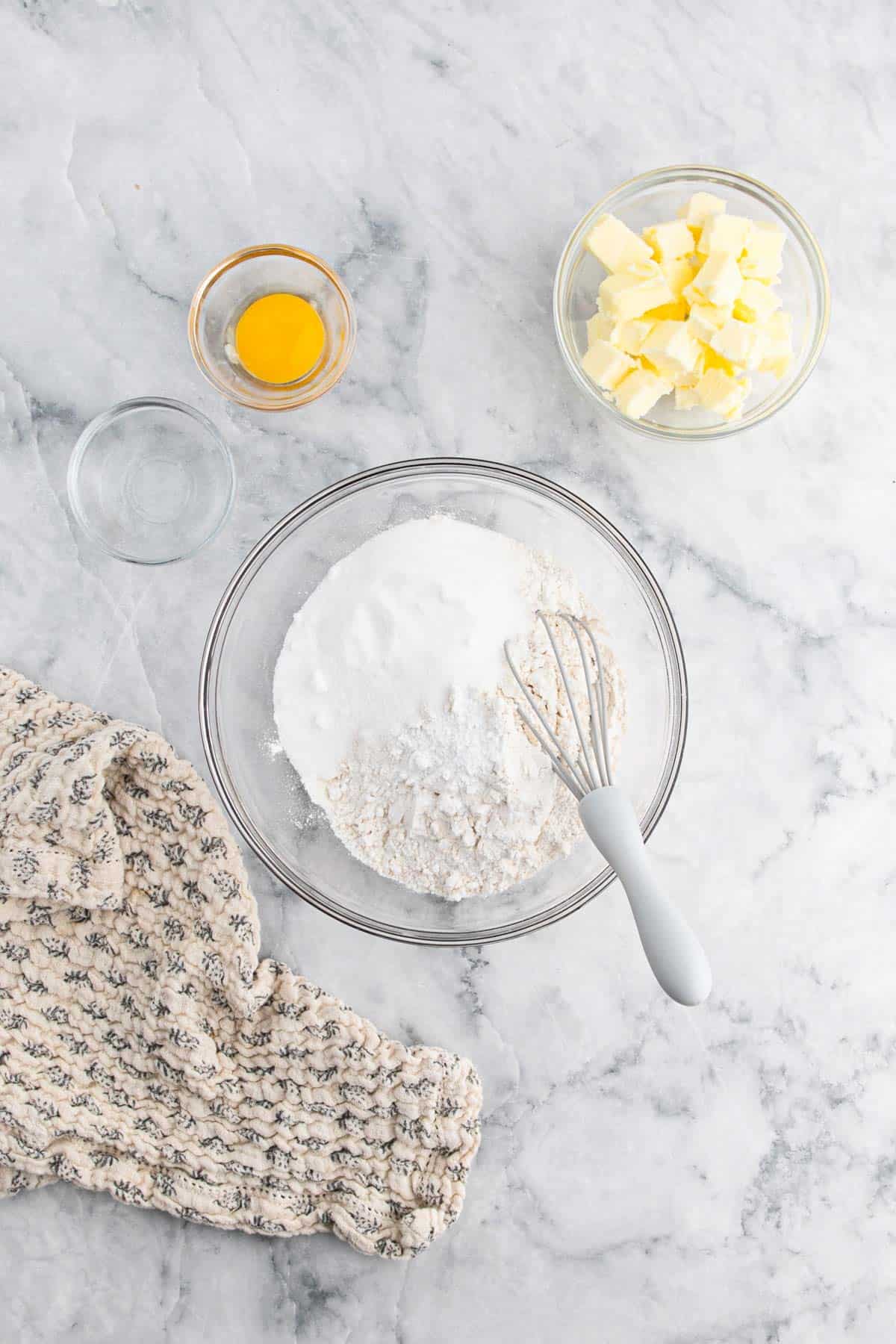 Flour, baking powder, salt, and sugar in a bowl with a whisk.