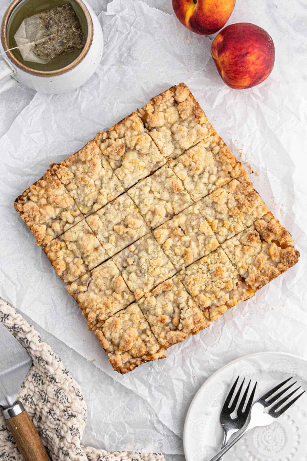 Peach bars removed from the pan and cut into squares on a piece of parchment.