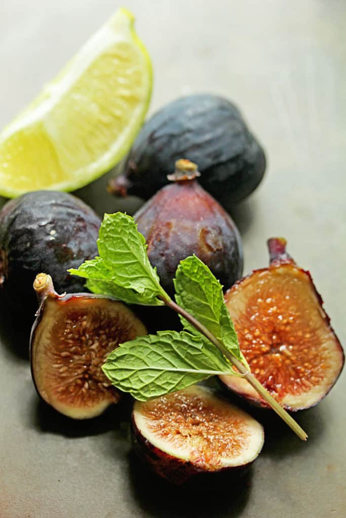 Close up of figs, a piece mint and a sliced lime