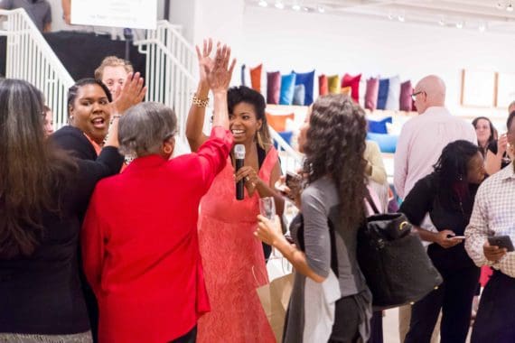 Jocelyn Delk Adams gives a high five to a launch party attendee