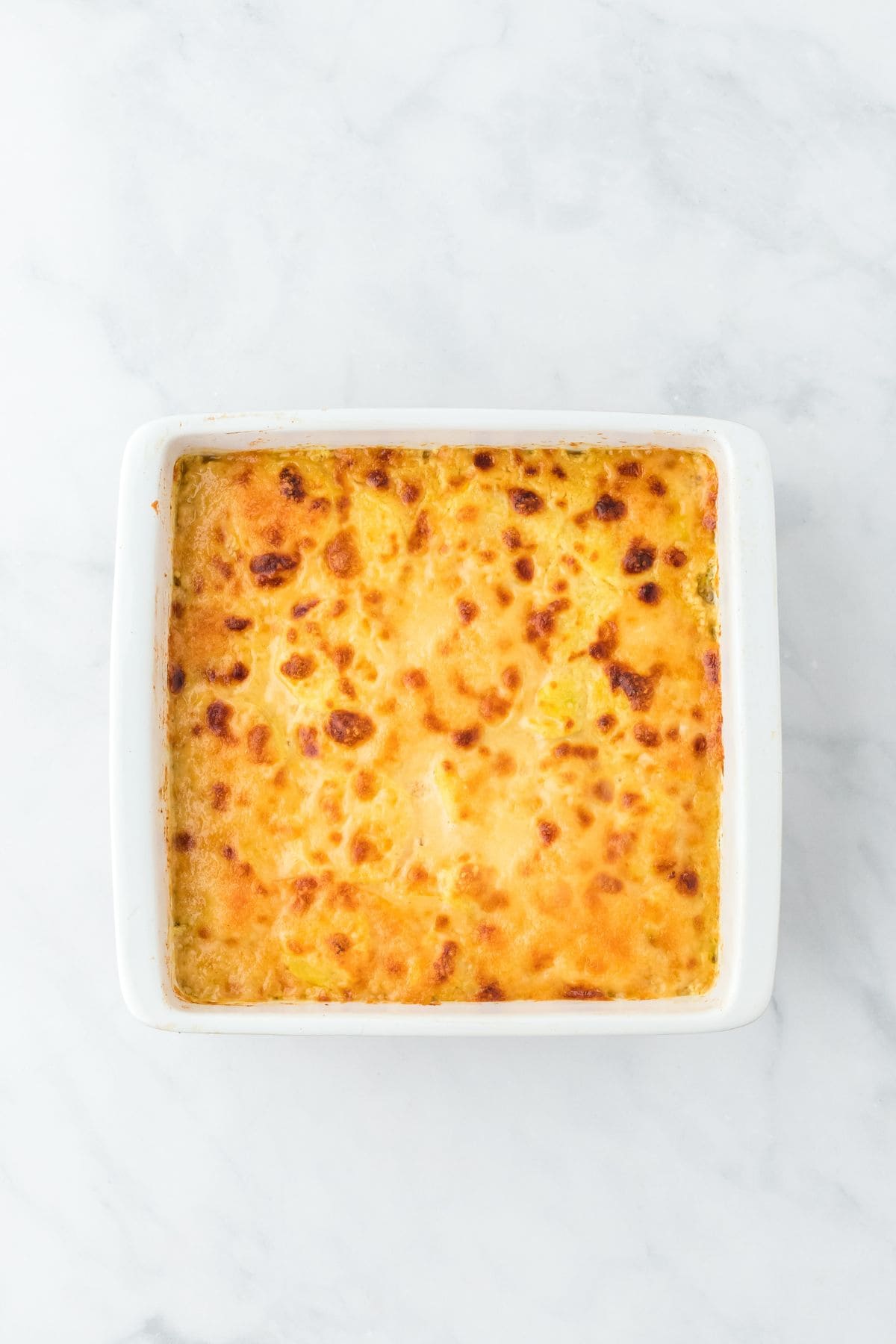 A square, golden-browned potato and squash gratin with a crispy top layer