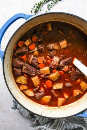 Classic beef soup being stirred in a large pot