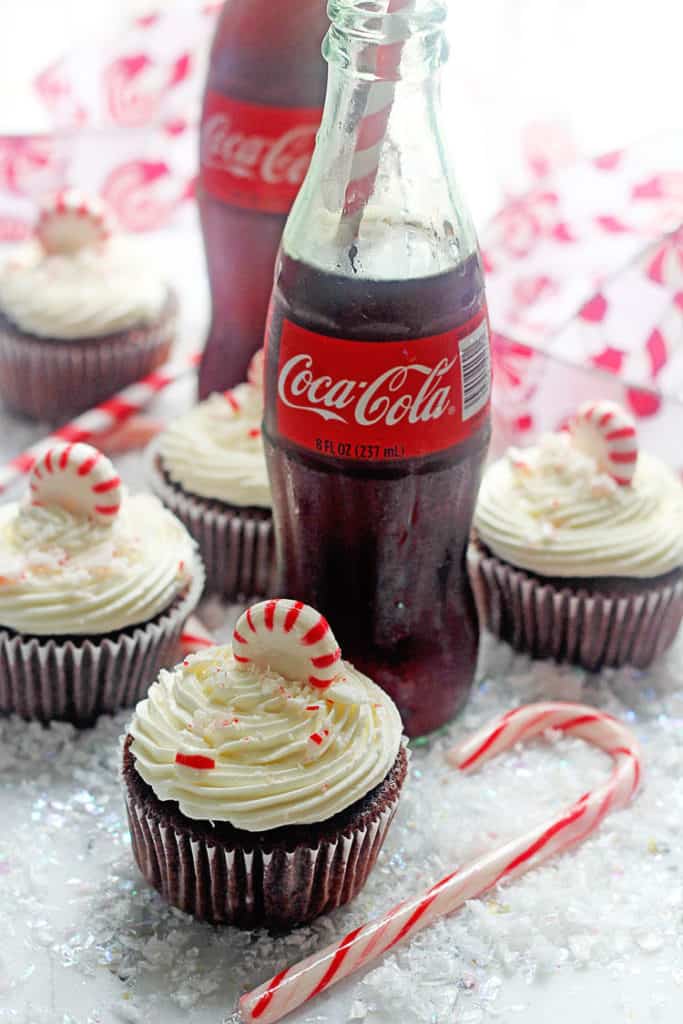 Coca Cola cupcakes with a delicious peppermint frosting surrounded by bottles of Coke