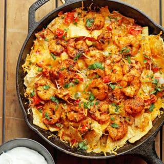 Blackened Shrimp Nachos in a large cast iron skillet ready to serve for super bowl