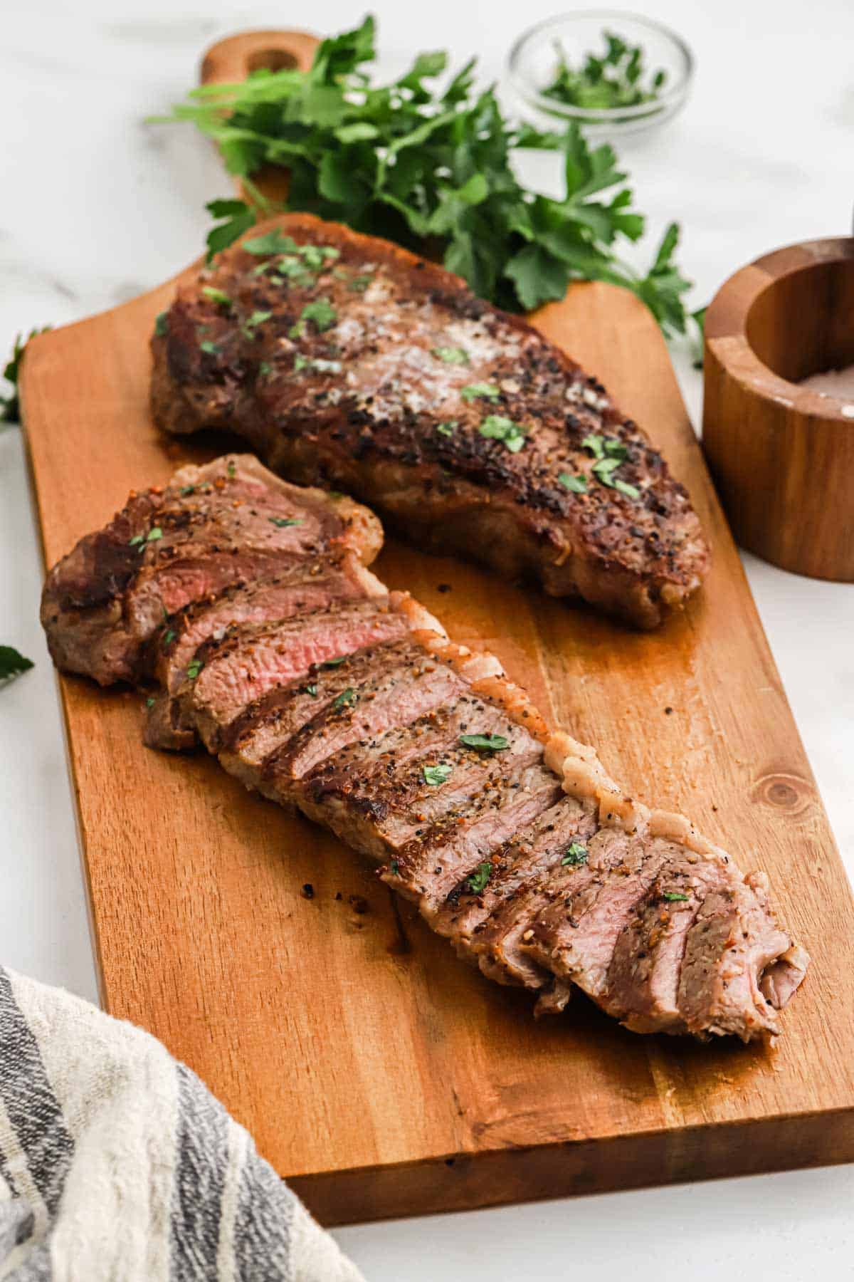 Pan seared steak sliced on a cutting board.