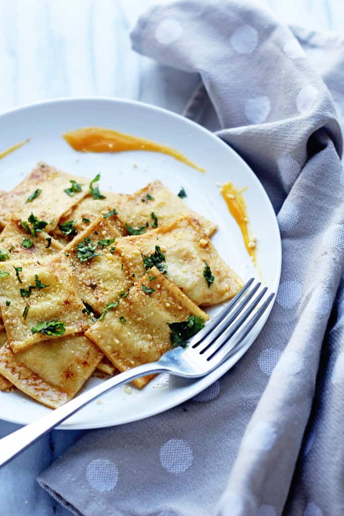 Butternut Squash Ravioli on a white plate with a silver fork