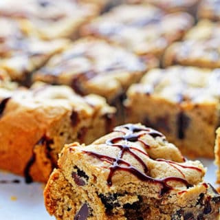 Chocolate chip cookie bars cut with one having a bite taken out