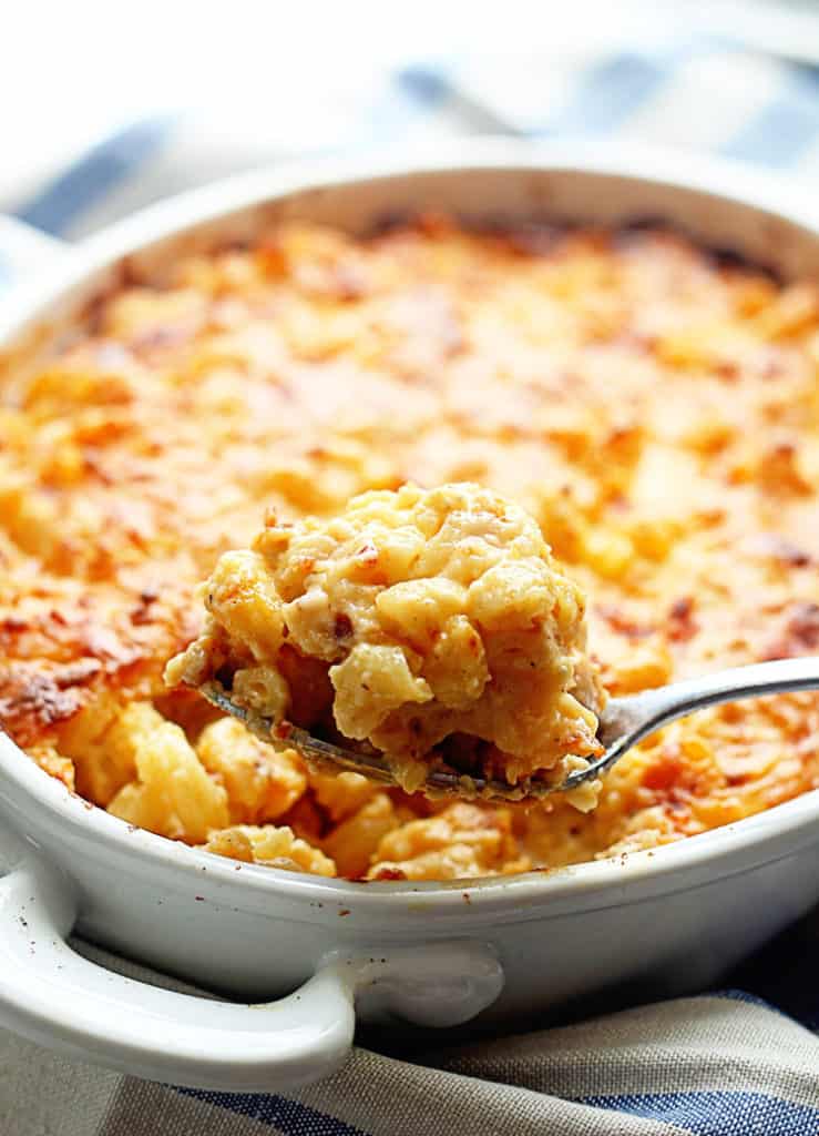 A spoon full of Southern Baked Macaroni and Cheese Recipe is pulled from the dish containing the soul food mac and cheese.