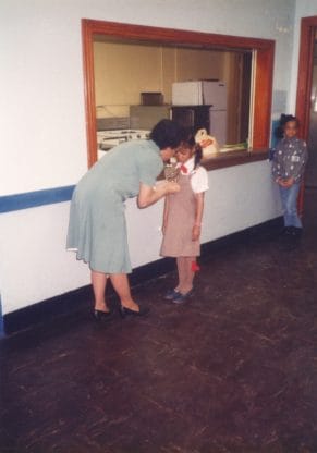 Young Jocelyn Delk Adams receiving a badge as a girl scout