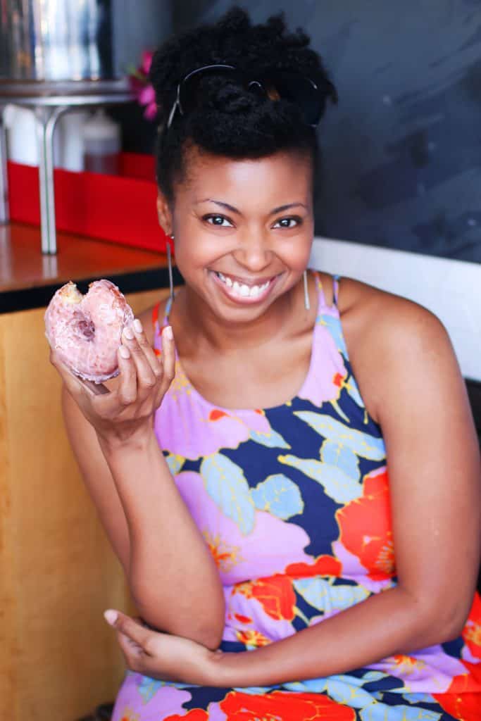 Jocelyn Delk Adams poses for a photo holding a Doughnut from Sidecar Doughnuts in L.A.