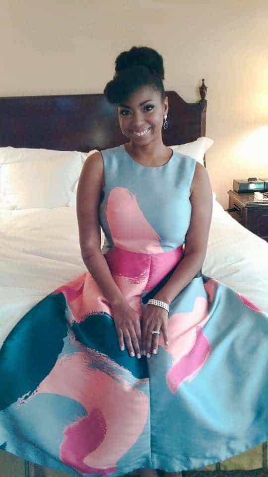 Jocelyn Delk Adams posing on the hotel bed as she gets ready to attend the 2016 NAACP Image Awards