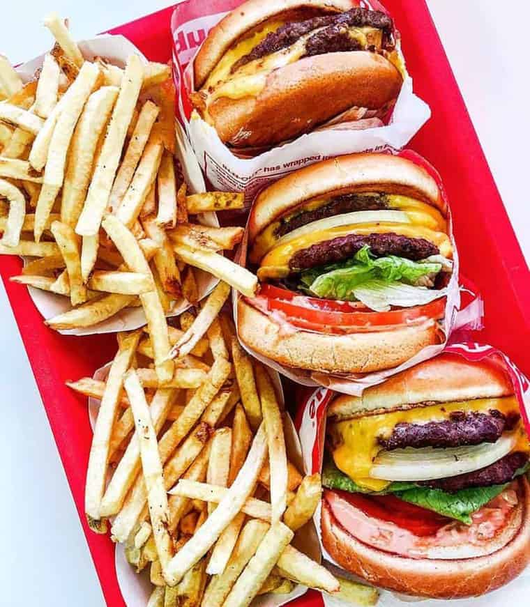 Overhead shot of three cheeseburgers and fries from In N' Out Burger, which is considered one of the best restaurants in L.A.