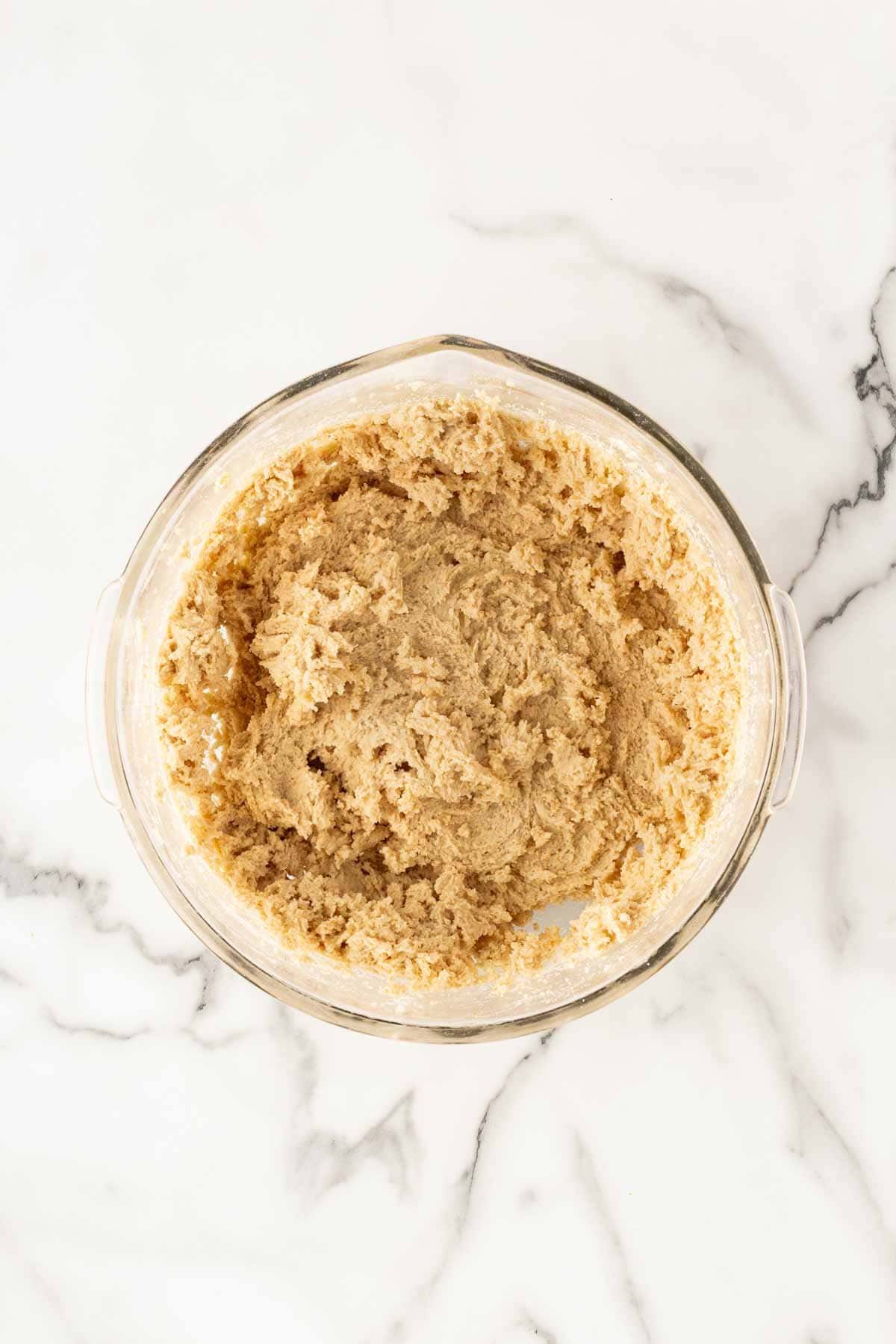 Cookie dough mixture fully combined in a glass mixing bowl