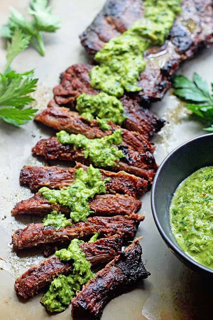 Thinly sliced pieces of skirt steak topped with chimichurri sauce.
