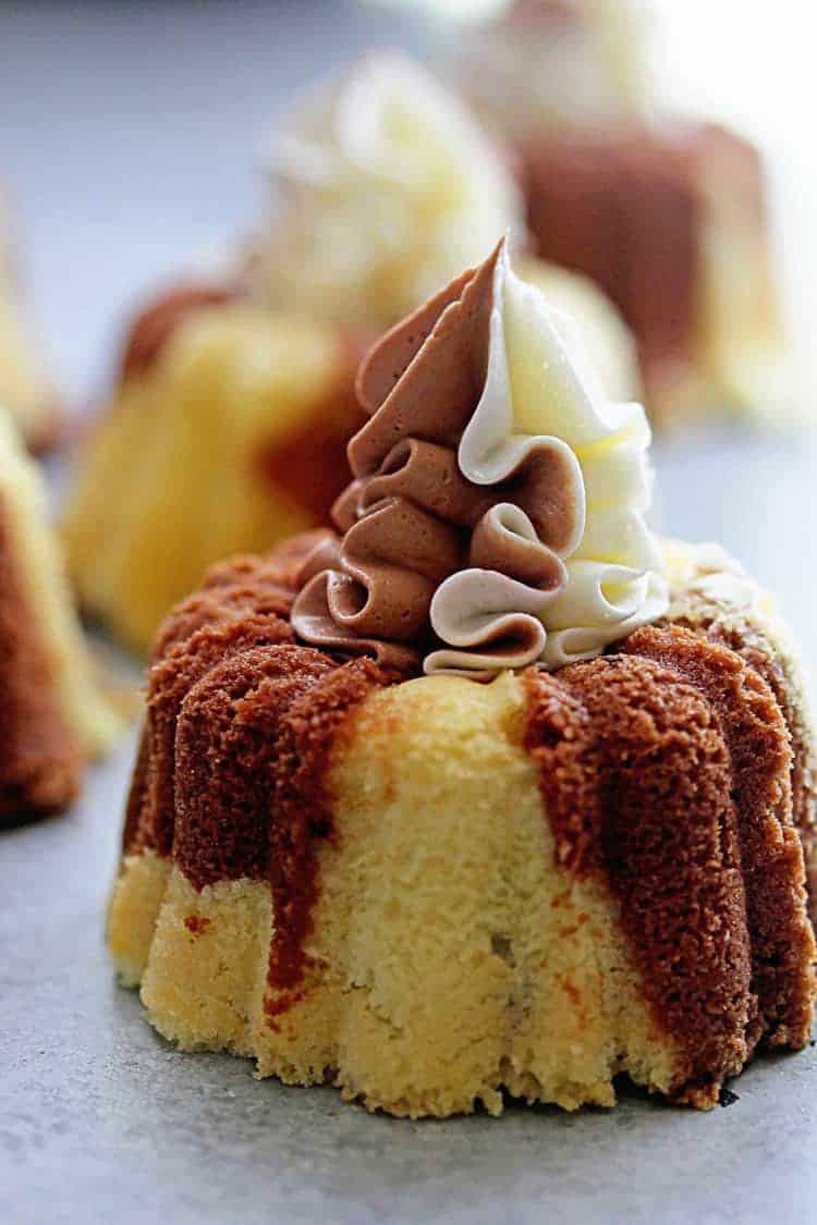 Close up a marble cupcake with chocolate and vanilla frosting and more in the background