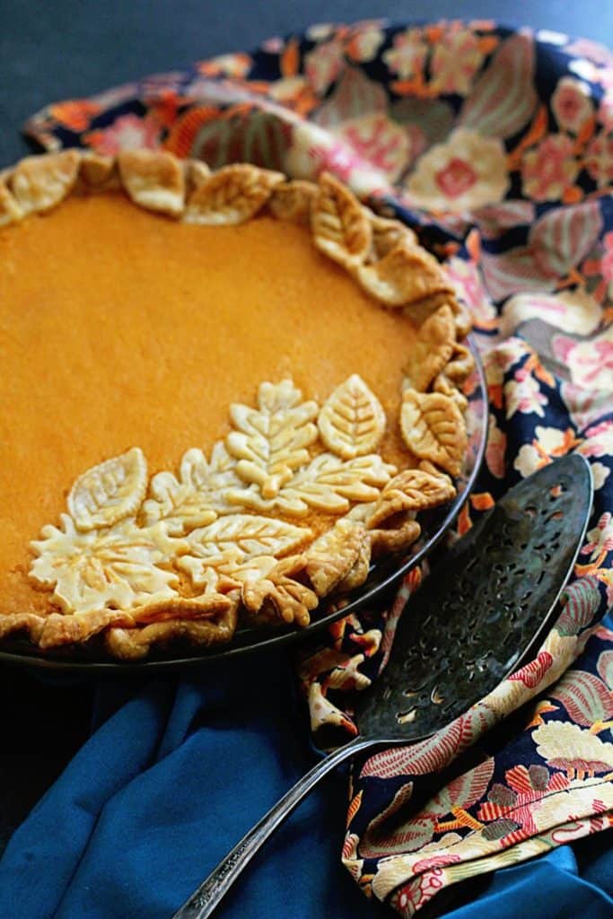 A close up of baked sweet potato chess pie with server ready to serve