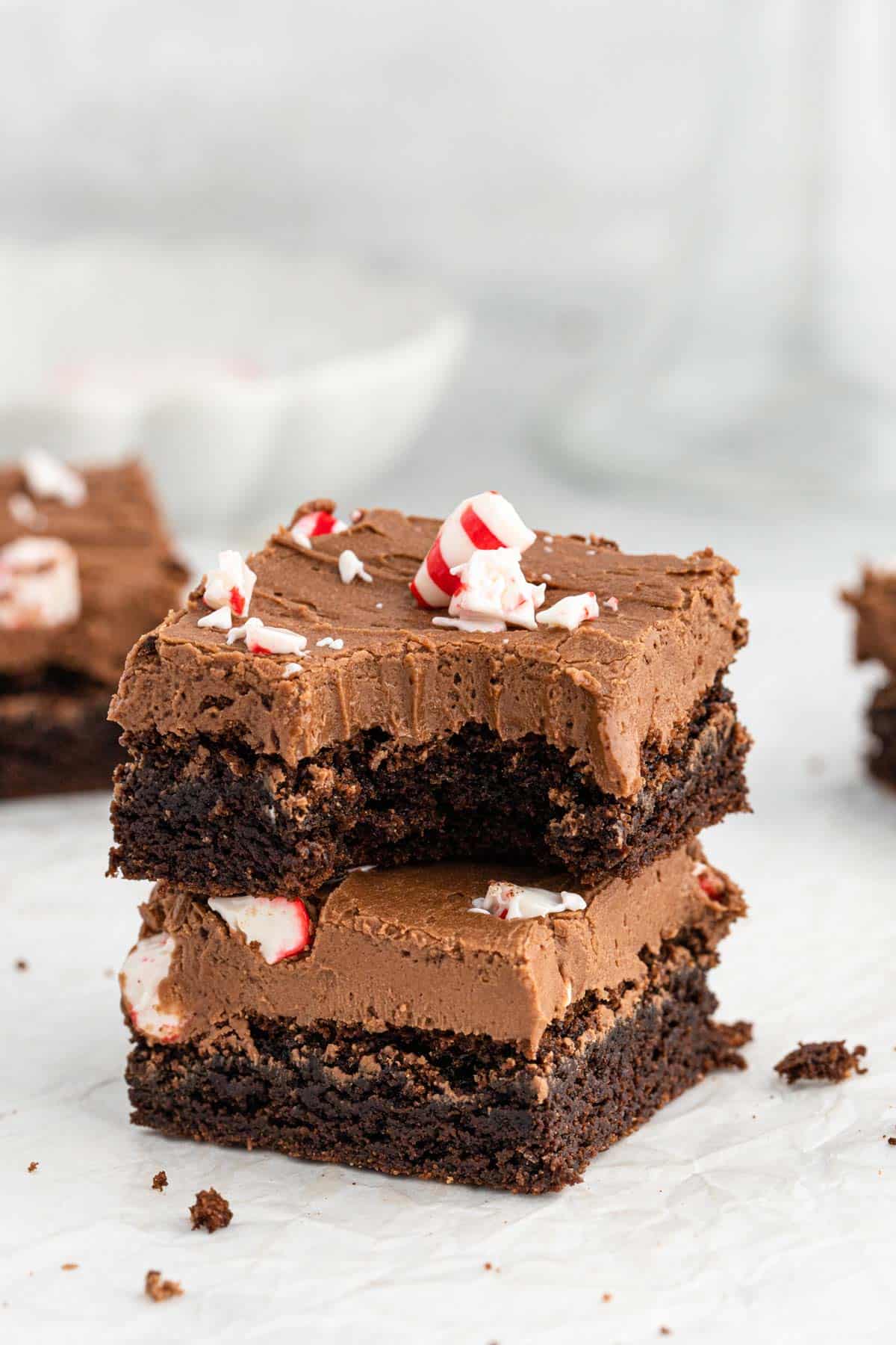 Close up of peppermint brownies with peppermint frosting and crushed peppermint on gray background