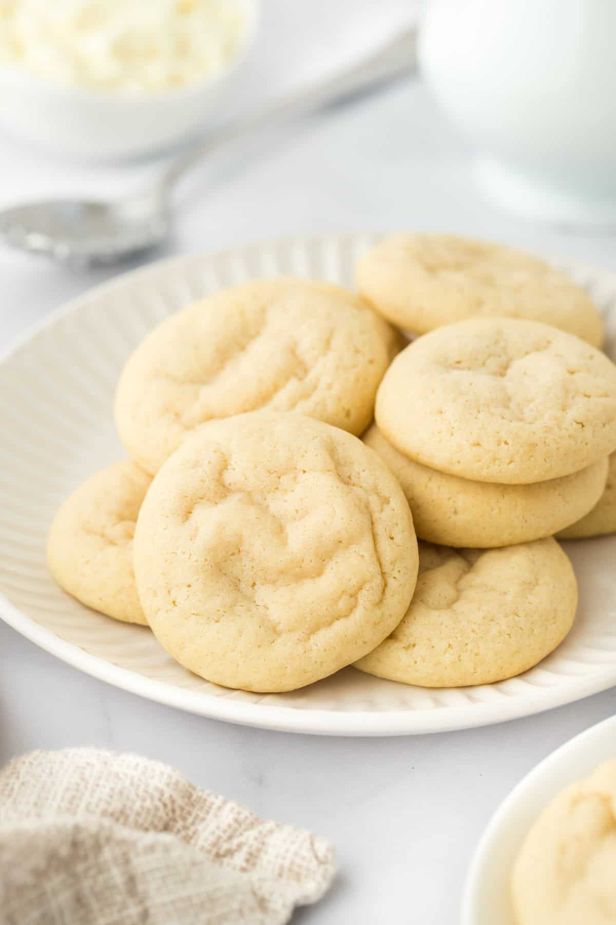 Italian ricotta cookies on a white plate on a white countertop