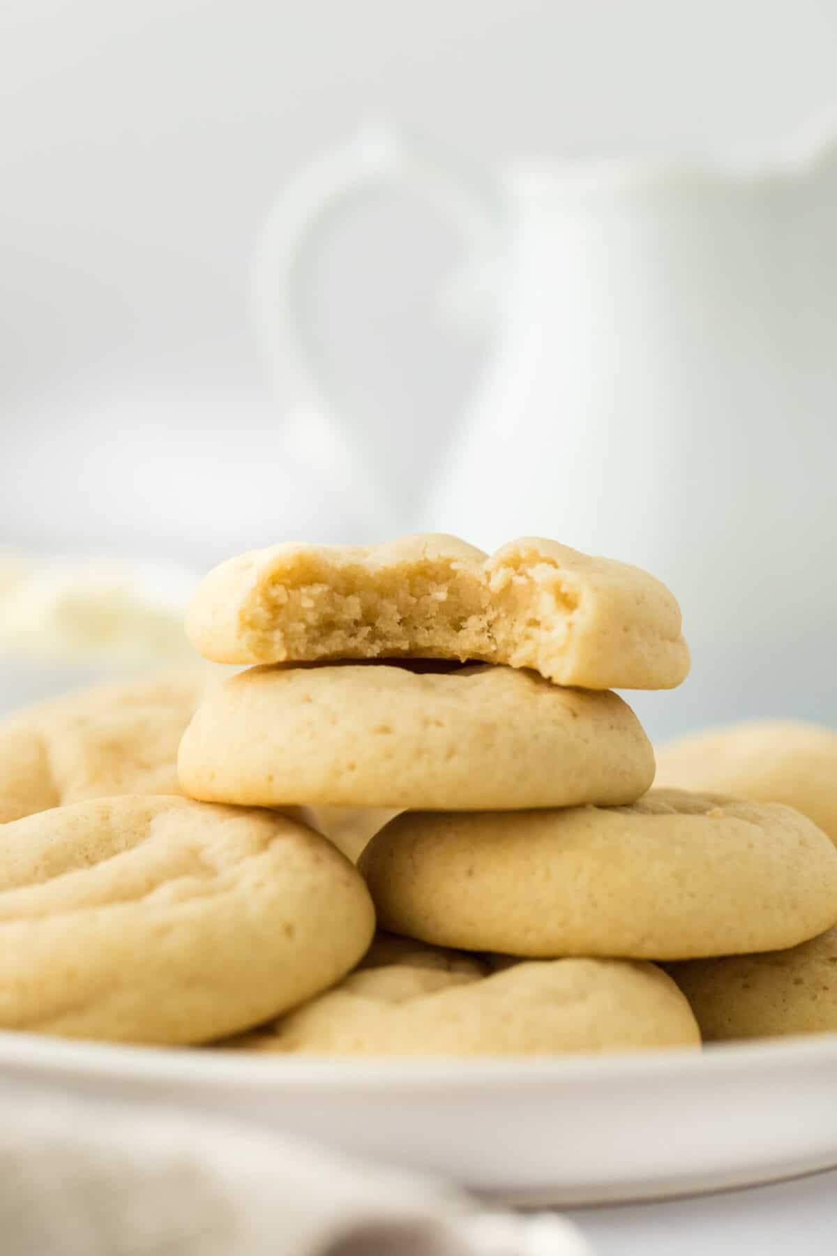 Stacked ricotta cheese cookies on top of each other with a bite in one