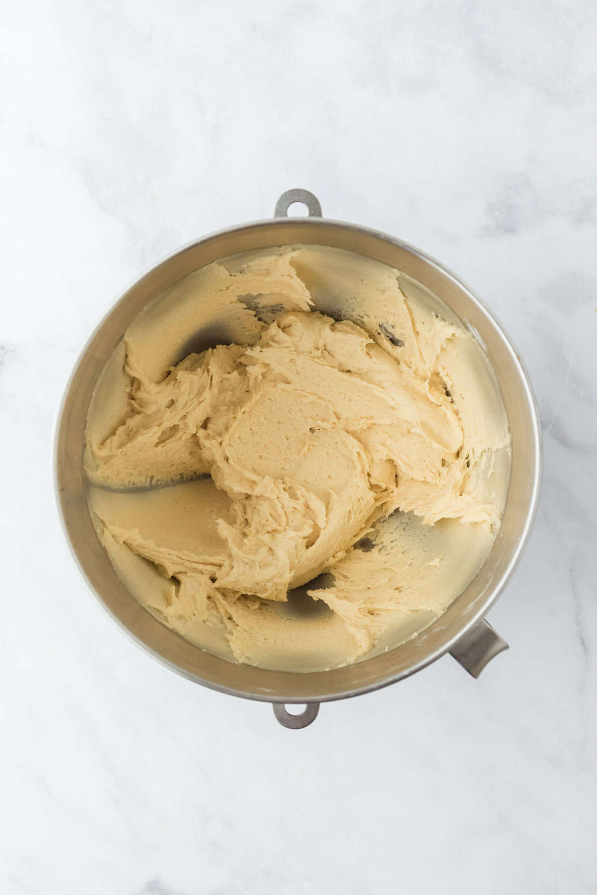 Finished ricotta cookie recipe batter in a stand mixer bowl on white background