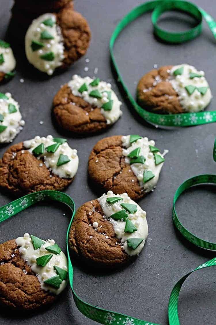 White Chocolate Ginger Cookies decorated with tiny green Christmas trees and green ribbon next to the cookies.