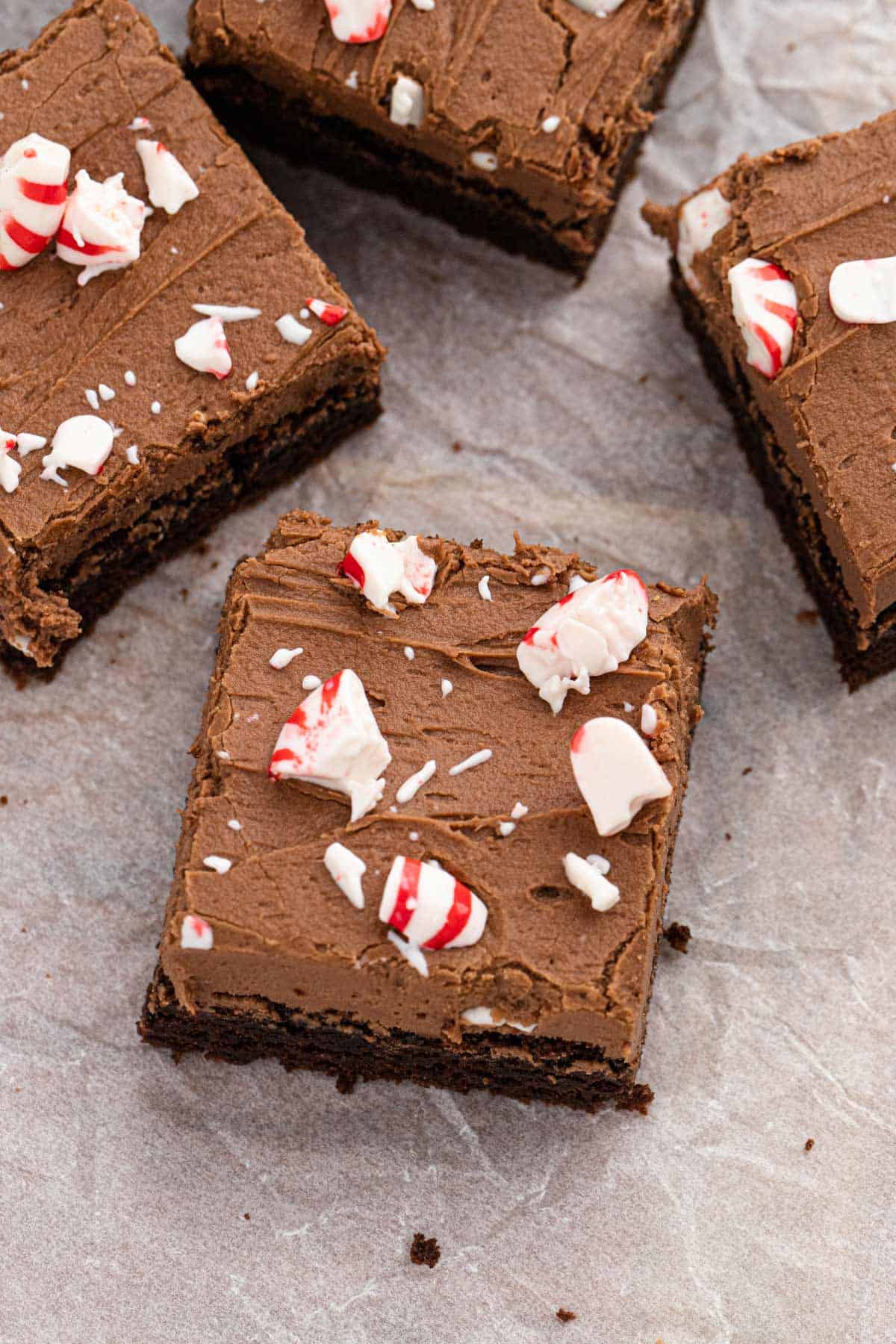 Peppermint brownies cut into squares on a piece of parchment paper.