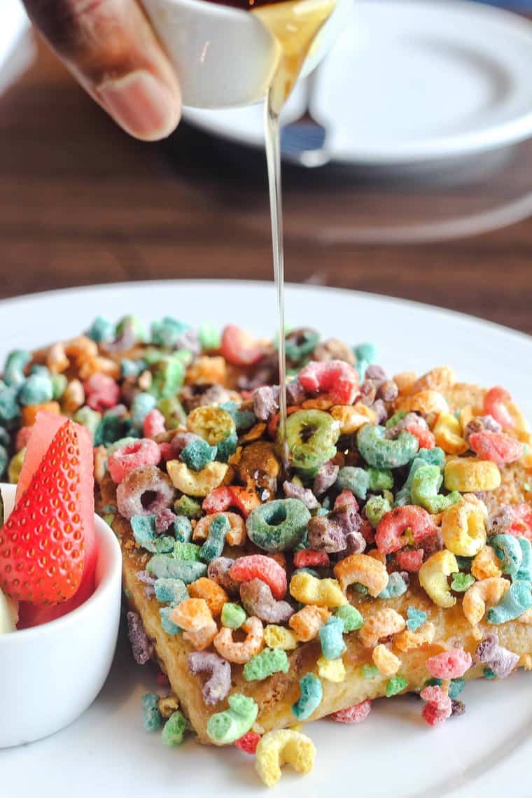 Cereal French toast with syrup being poured on top of it