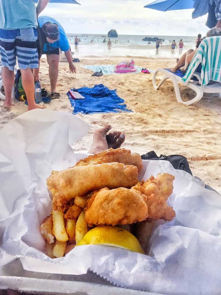 Jocelyn Delk Adams on the beach partaking in fresh, fried fish and fries