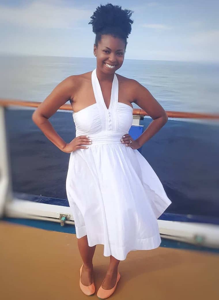 Photo of Jocelyn Delk Adams wearing a sleeveless white dress onboard the Carnival Pride