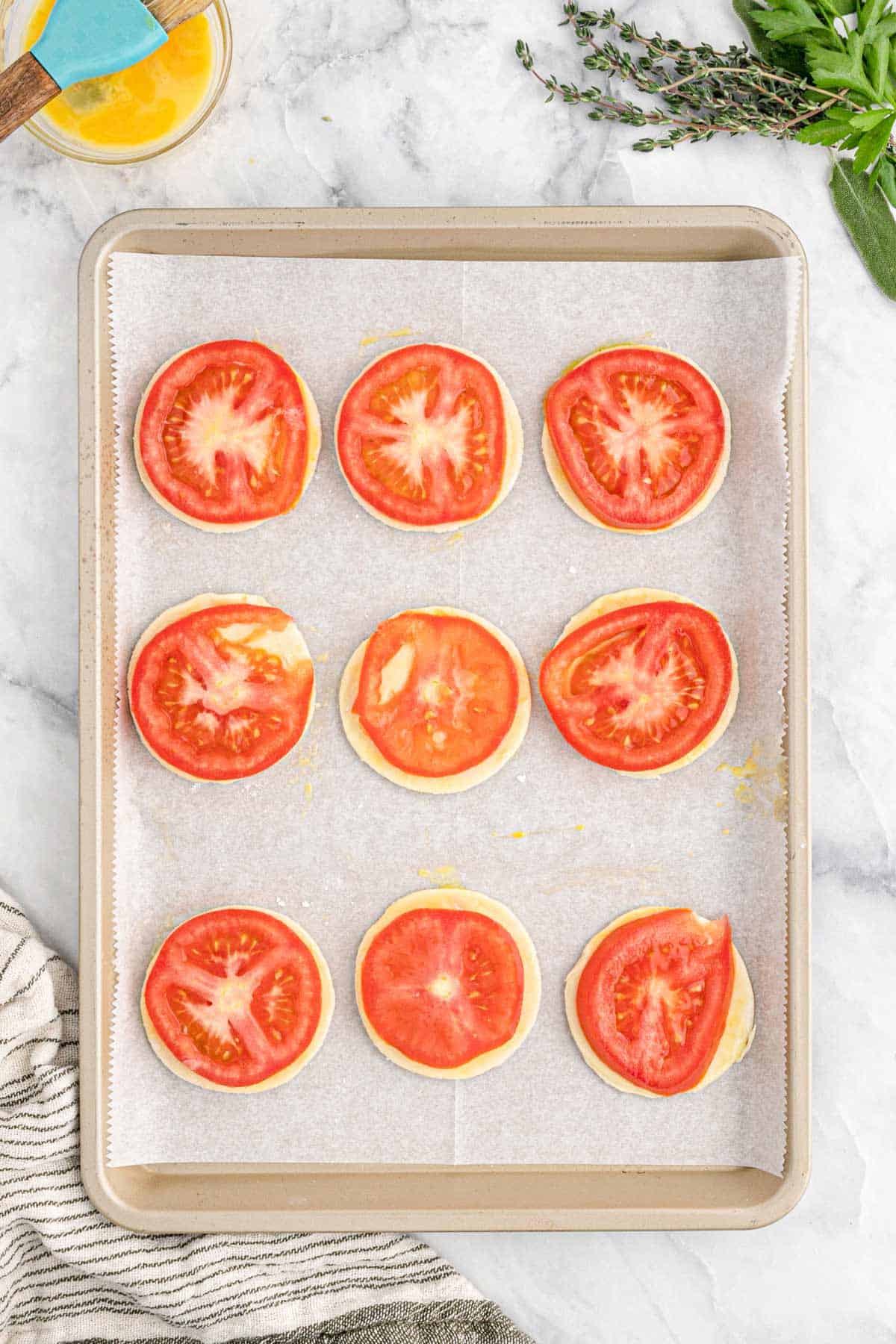 Sliced tomatoes placed on top of the puff pastry.
