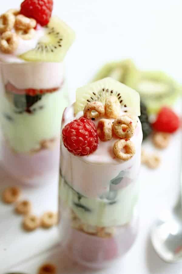 Close up of cereal parfaits topped with fresh raspberries and kiwi