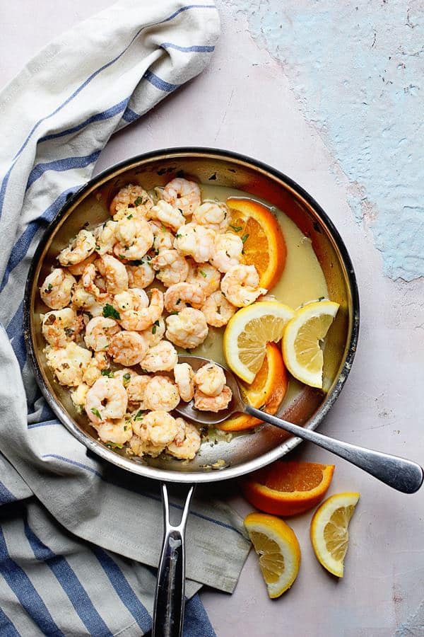 Overhead shot of this Citrus Shrimp dish in a frying pan with slices of orange and lemon.