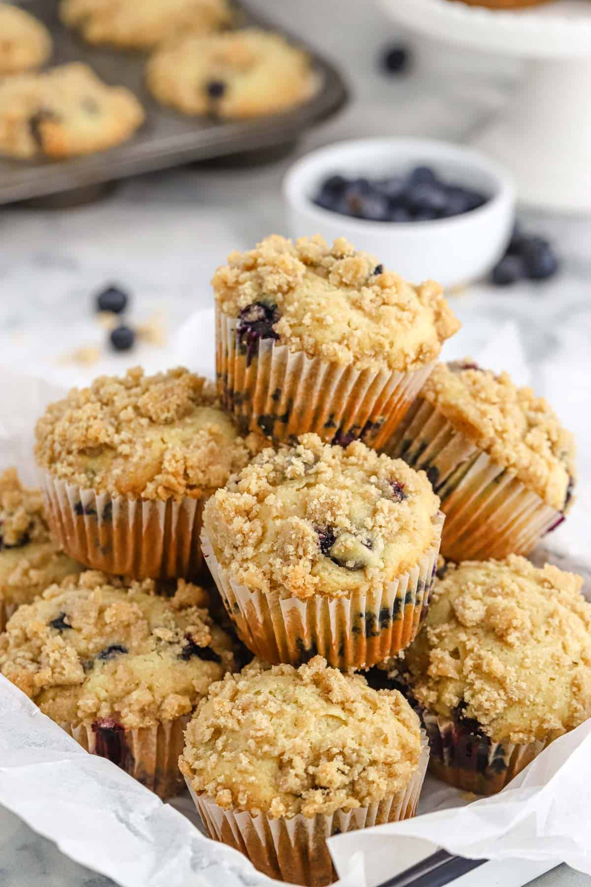 A pile of blueberry crumb muffins in a basket.