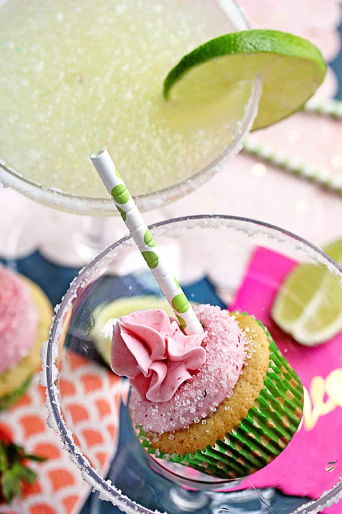 Berry Margarita Cupcake in a margarita glass with a straw in it and a margarita drink next to it