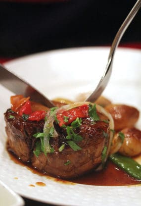 Meat dish served on a white plate at Les Papilles