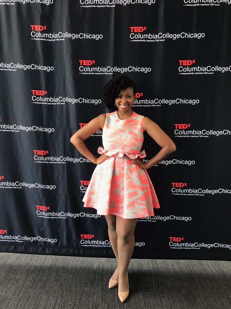 Jocelyn standing in front of a TEDX sign before her TedTalk