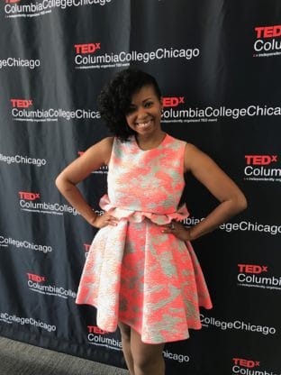 Jocelyn standing in front of a TEDX sign before her TedTalk at Columbia College in Chicago