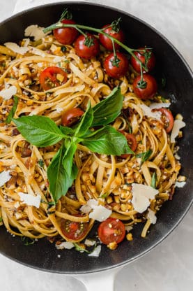 Overhead shot of Summer Brown Butter Pasta for Two topped with cheese, tomatoes and basil